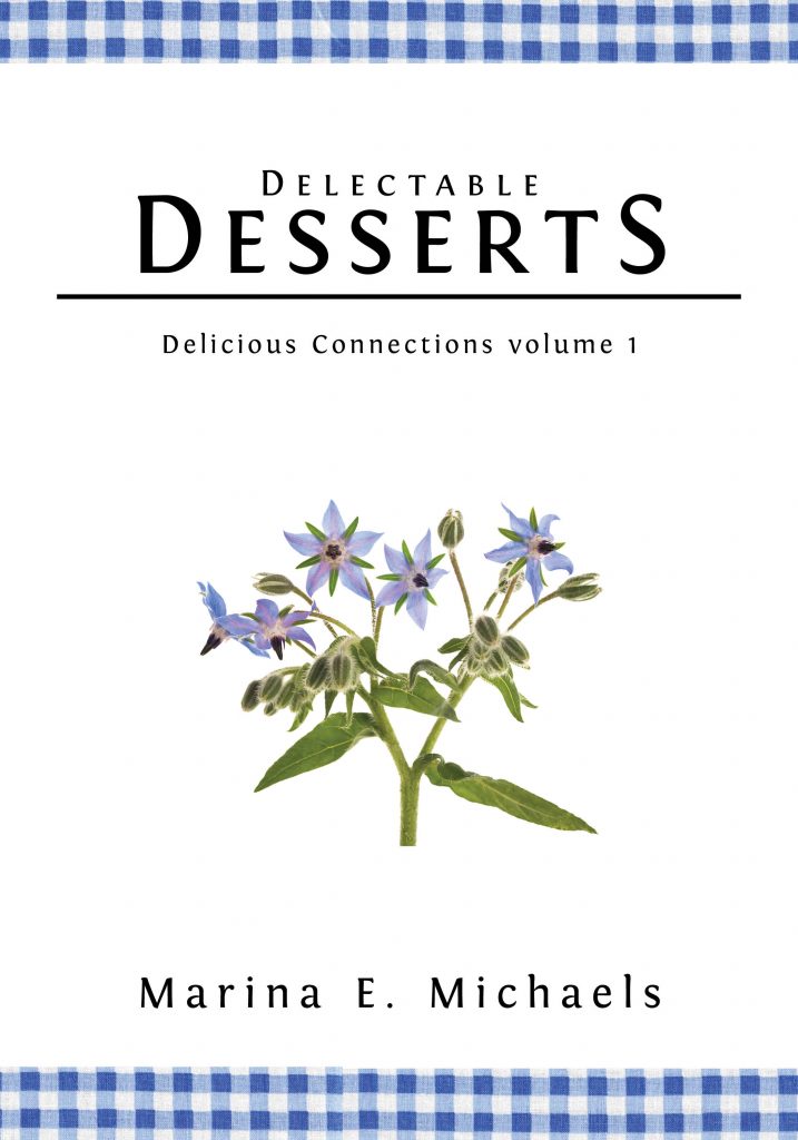 The cover of Delectable Desserts. Plain white cover with a blue gingham border at the top and bottom. Below the title is a spray of borage, which is a lovely periwinkle blue.